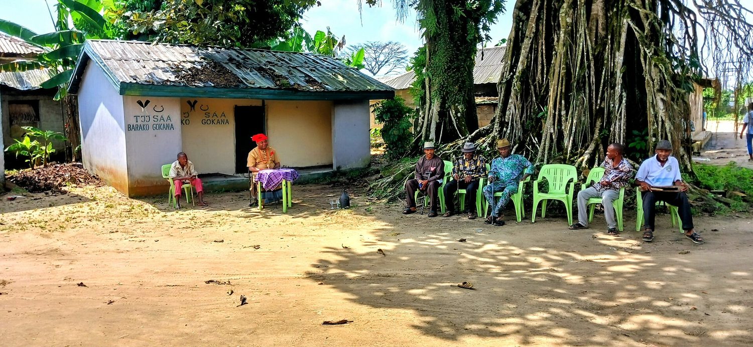 A farming community meeting outdoors during an extension session
